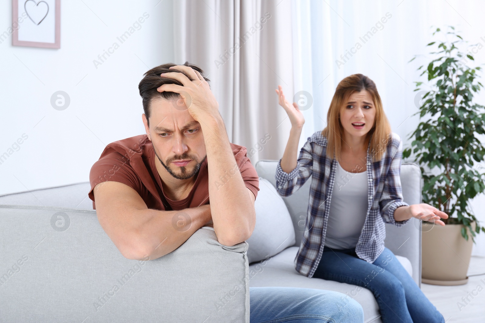 Photo of Couple arguing in living room. Relationship problems