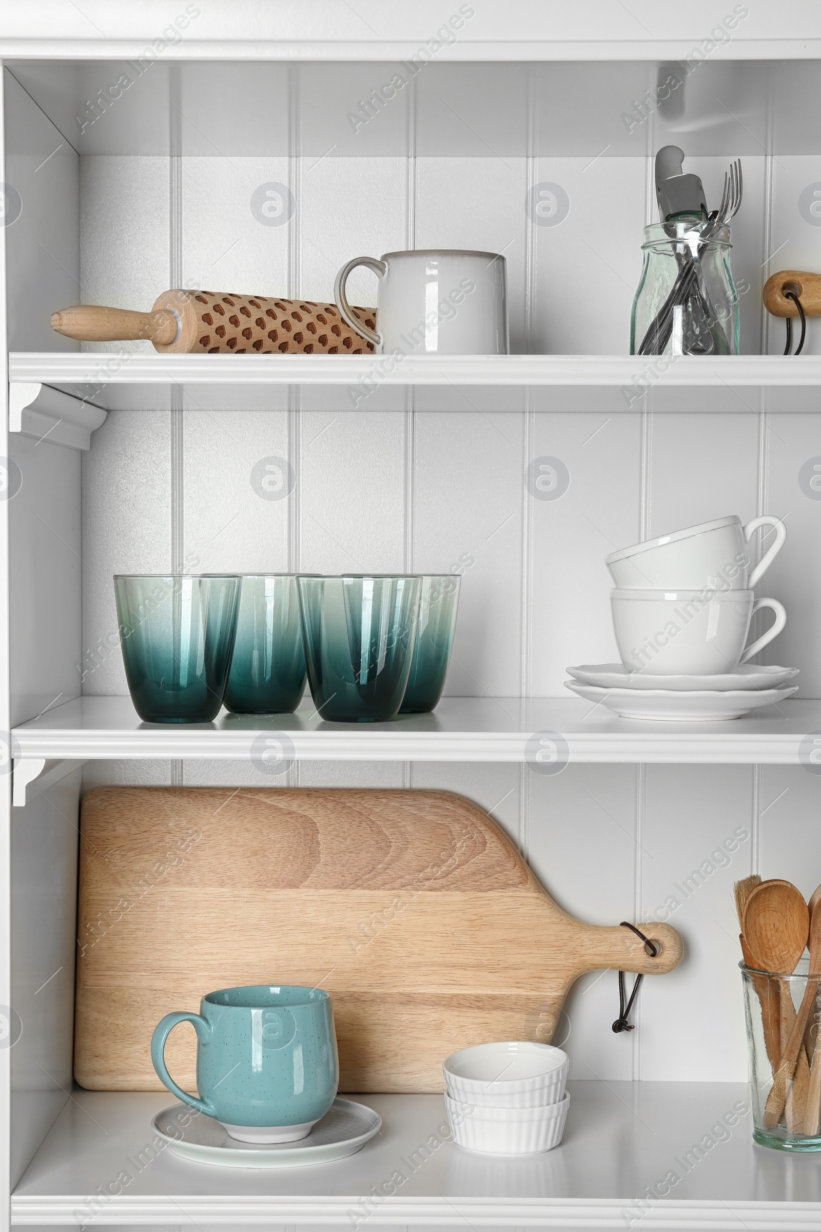 Photo of White shelving unit with set of dishware