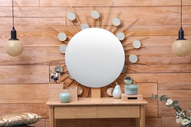 Dressing table with decor near wooden wall in room