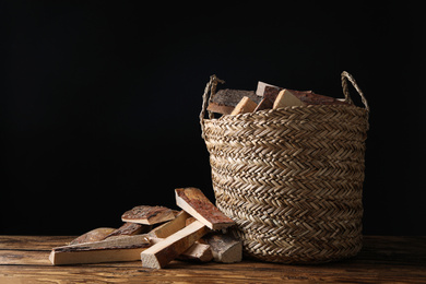 Cut firewood on table against black background