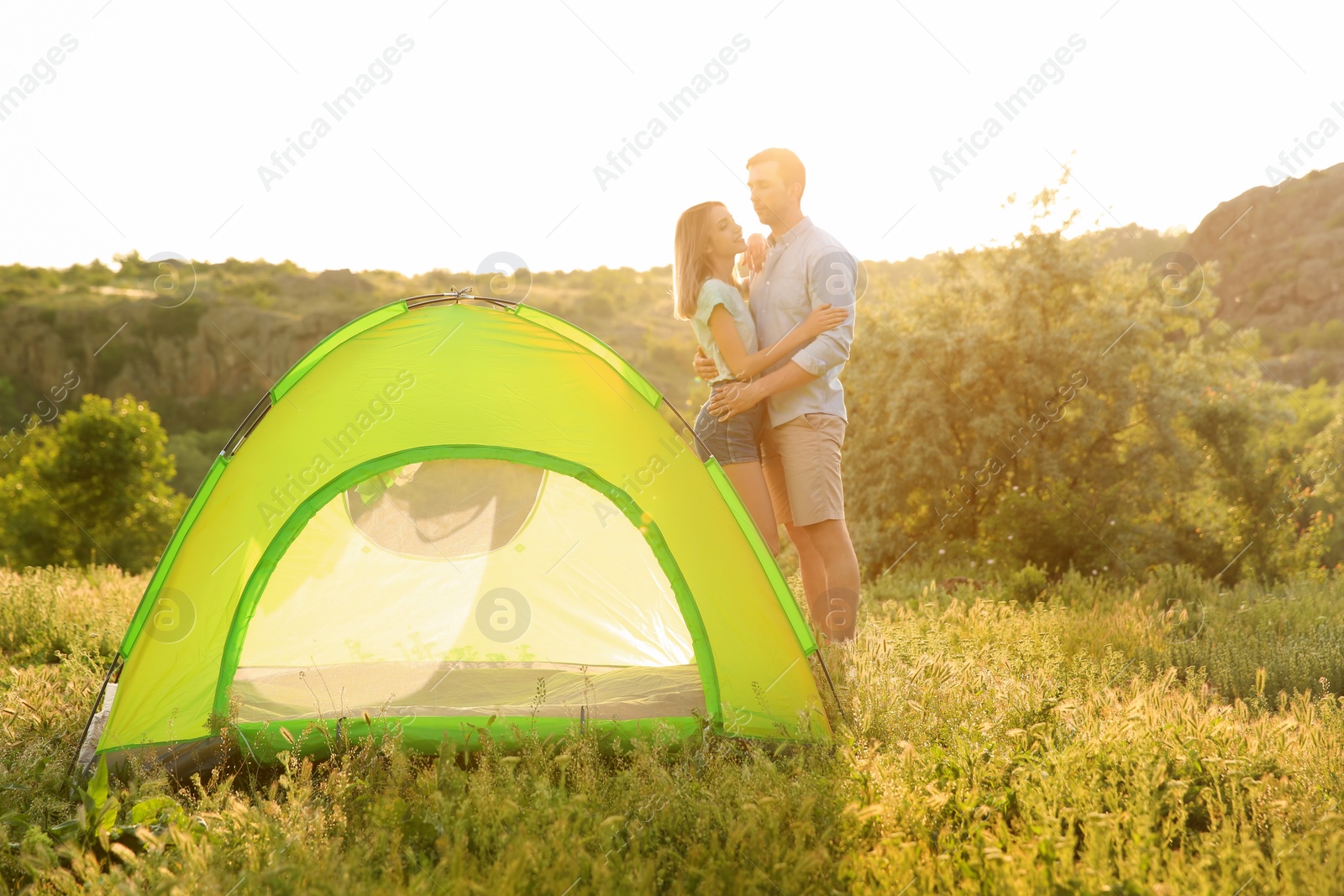 Photo of Young couple near camping tent in wilderness