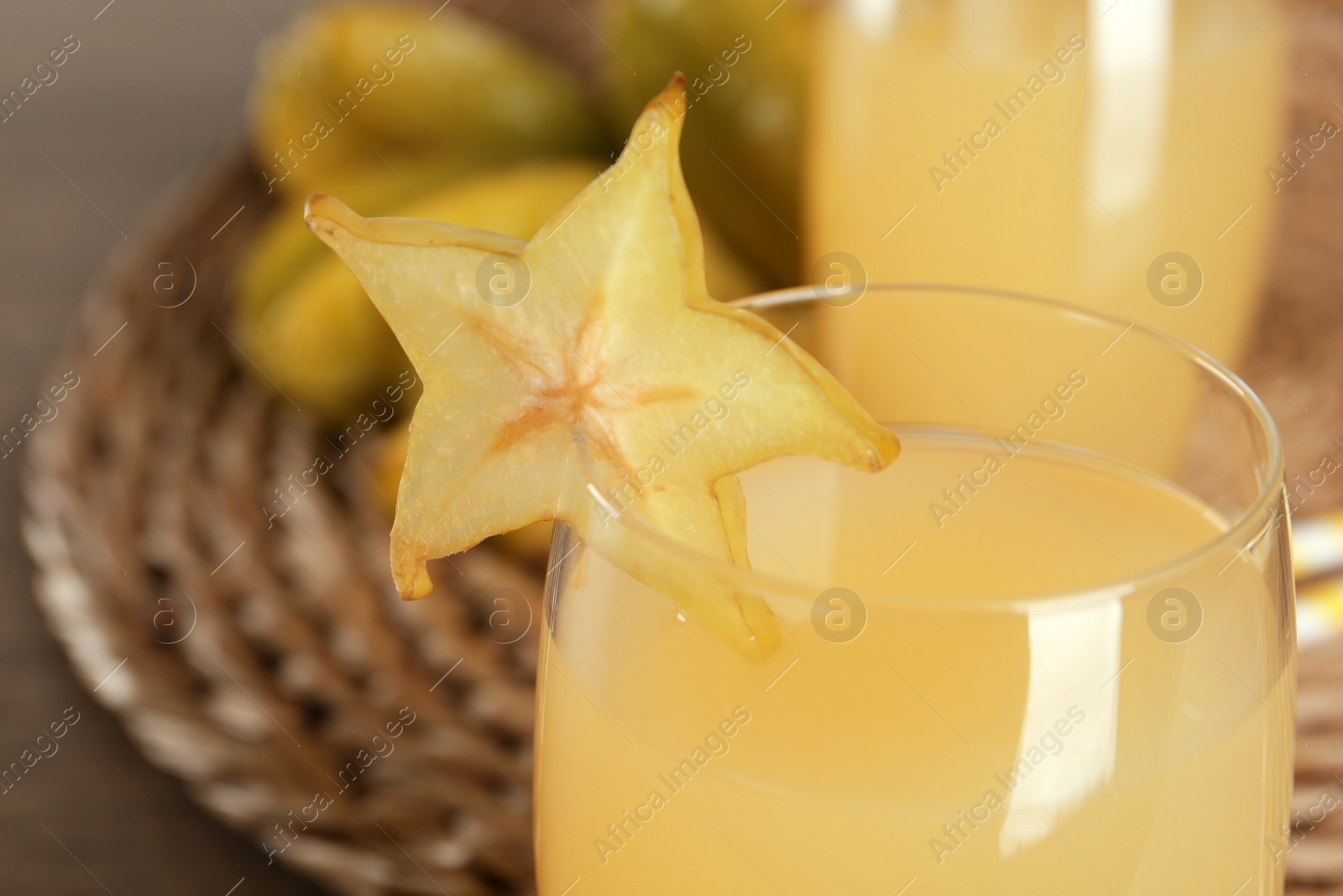 Photo of Delicious carambola juice in glass on table, closeup