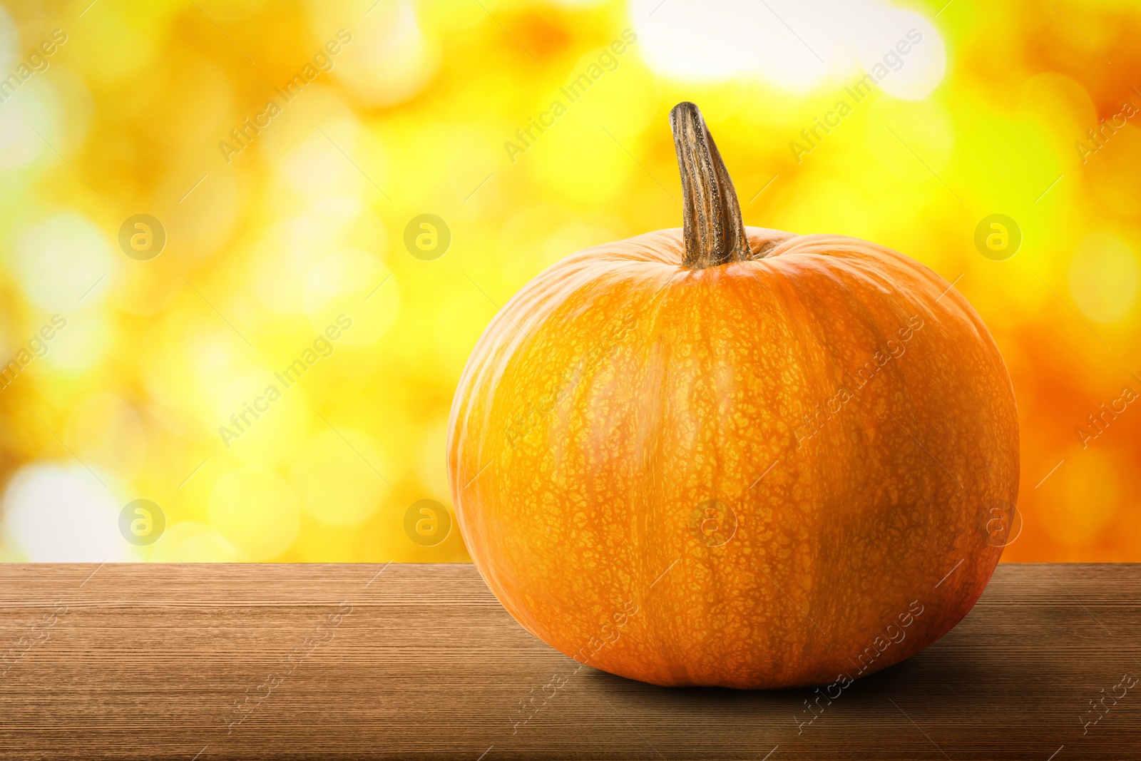Image of Fresh pumpkin on wooden table outdoors in autumn. Space for text