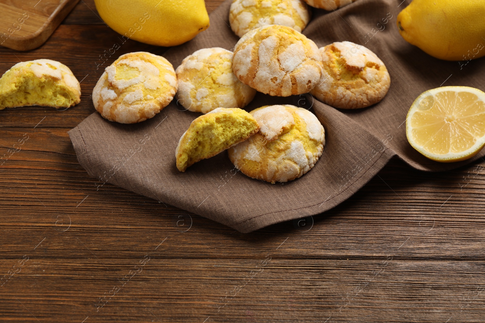 Photo of Delicious lemon cookies and citrus fruits on wooden table. Space for text