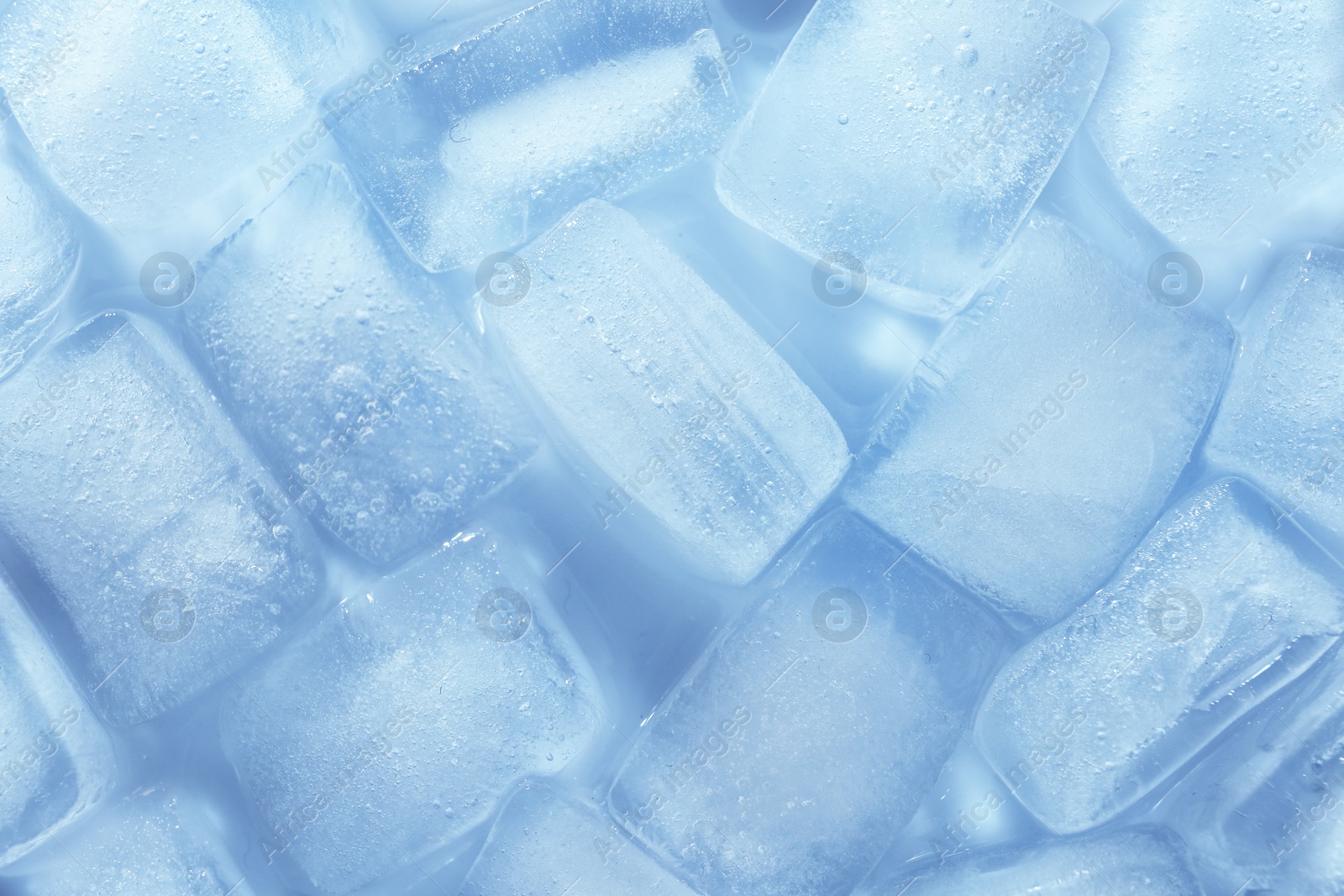 Photo of Melting ice cubes on color background, top view