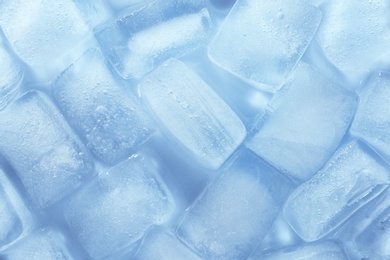 Melting ice cubes on color background, top view