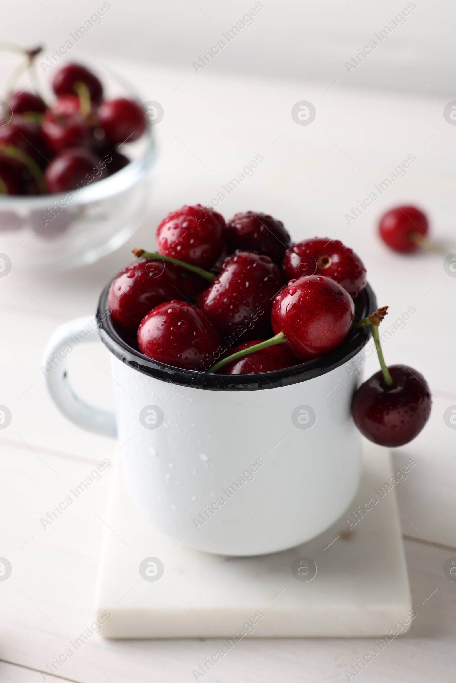 Photo of Fresh ripe cherries with water drops on white wooden table