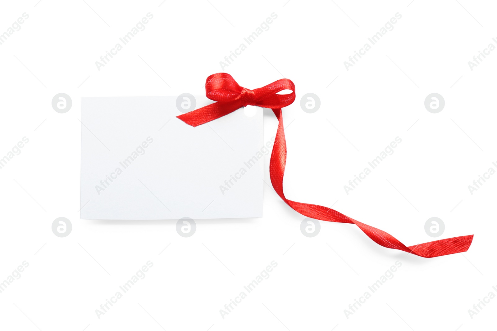 Photo of Blank gift tag with red satin ribbon on white background, top view