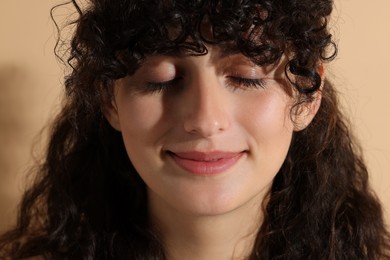 Photo of Portrait of beautiful young woman on beige background, closeup