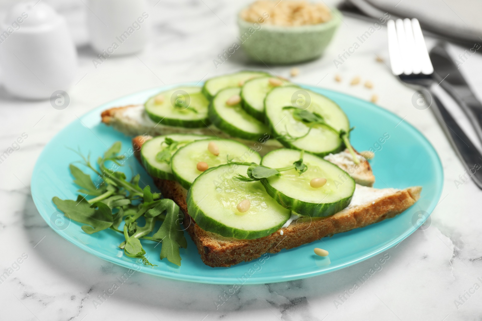 Photo of Plate with traditional English cucumber sandwiches on table, closeup