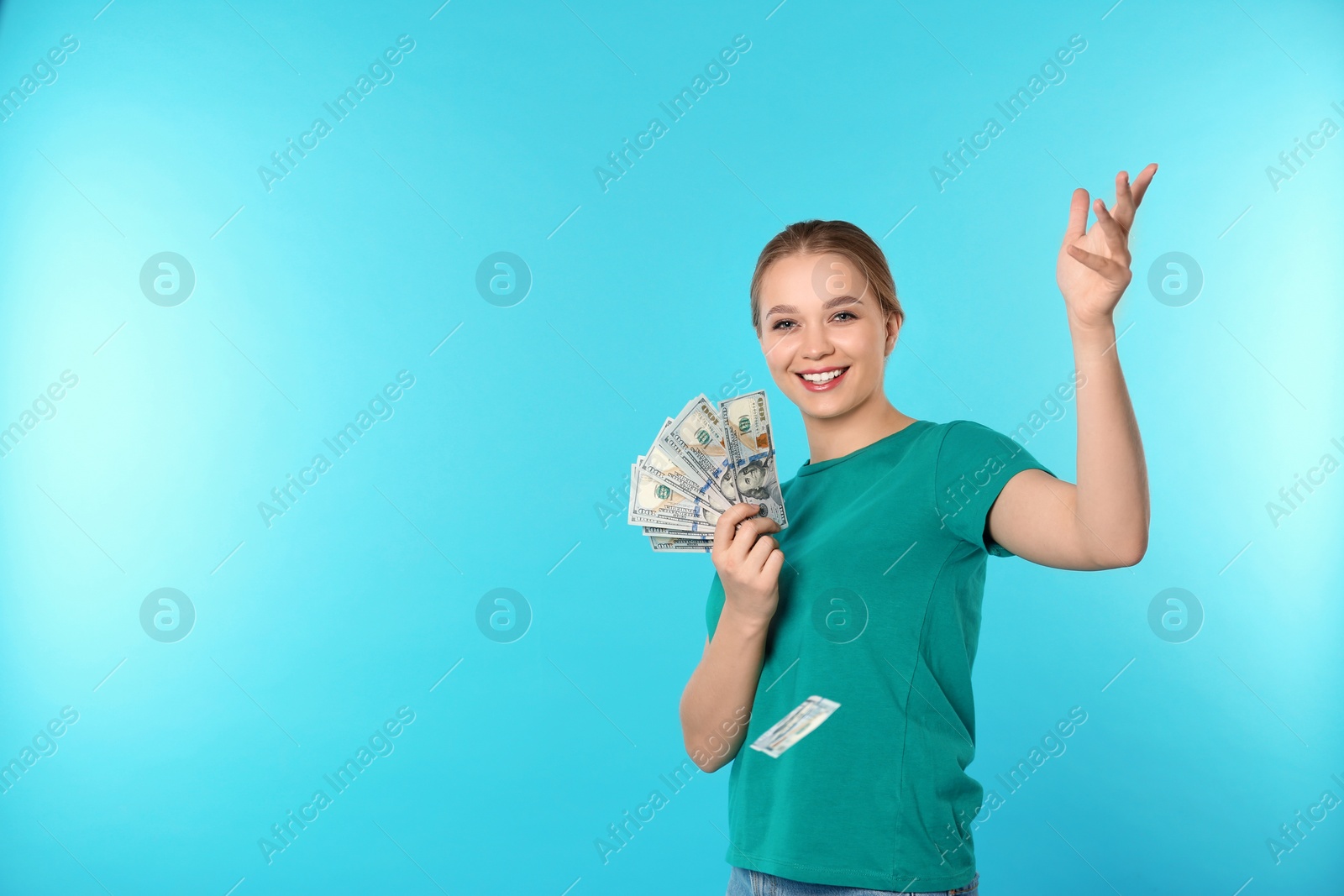 Photo of Happy young woman throwing money on color background. Space for text