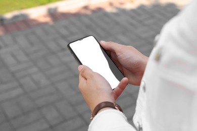 Photo of Woman with smartphone on pavement outdoors, closeup view