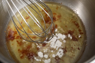 Photo of Cooking delicious turkey gravy. Mixing ingredients with whisk in pot, closeup