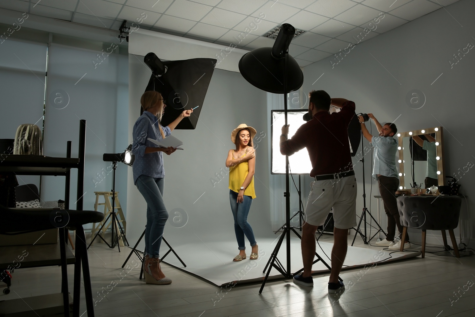 Photo of Professional team working with model in photo studio