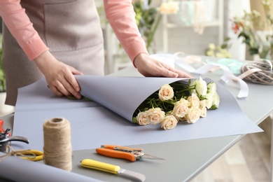 Photo of Female florist creating bouquet at workplace