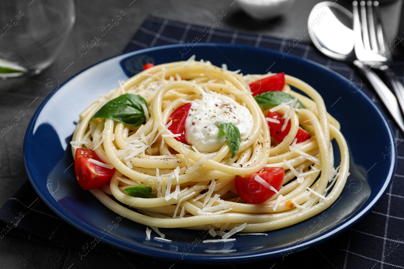 Photo of Delicious spaghetti with sour cream dressing on grey table, closeup