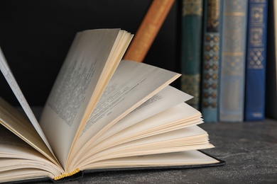 Photo of Open hardcover book on grey stone table, closeup