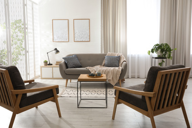 Photo of Modern living room interior with comfortable sofa and armchairs