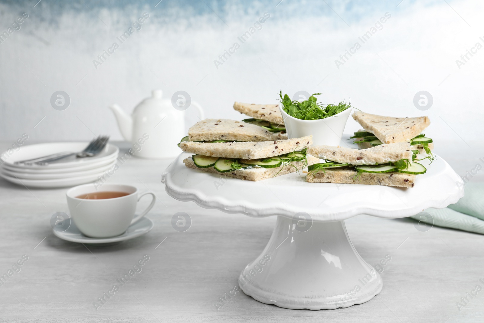 Photo of Stand with cucumber sandwiches on table. Space for text