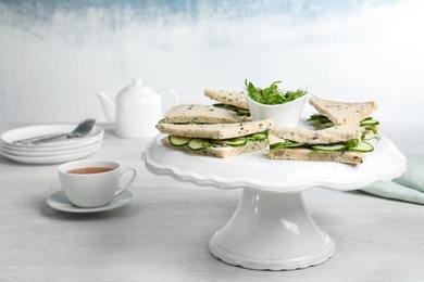 Photo of Stand with cucumber sandwiches on table. Space for text