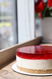 Photo of Delicious cheesecake with jelly and strawberries on wooden table. Space for text