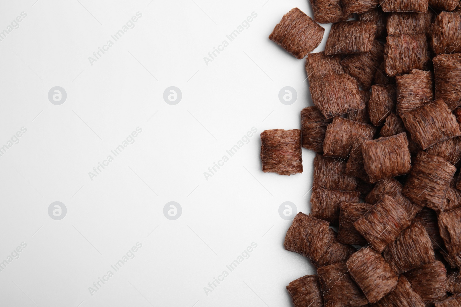 Photo of Chocolate cereal pads on white background, flat lay. Space for text