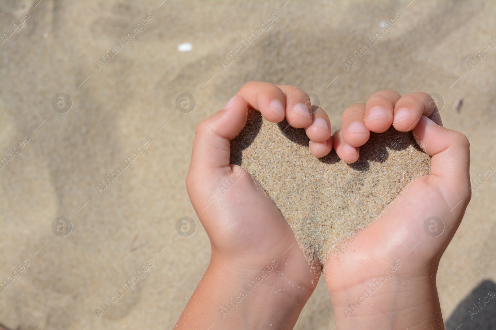 Photo of Child holding sand in hands outdoors, closeup with space for text. Fleeting time concept