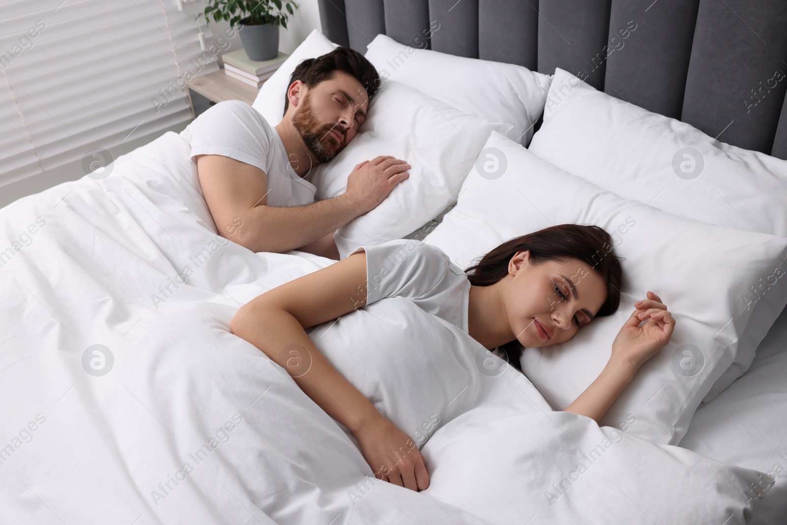 Photo of Lovely couple sleeping together in bed at home