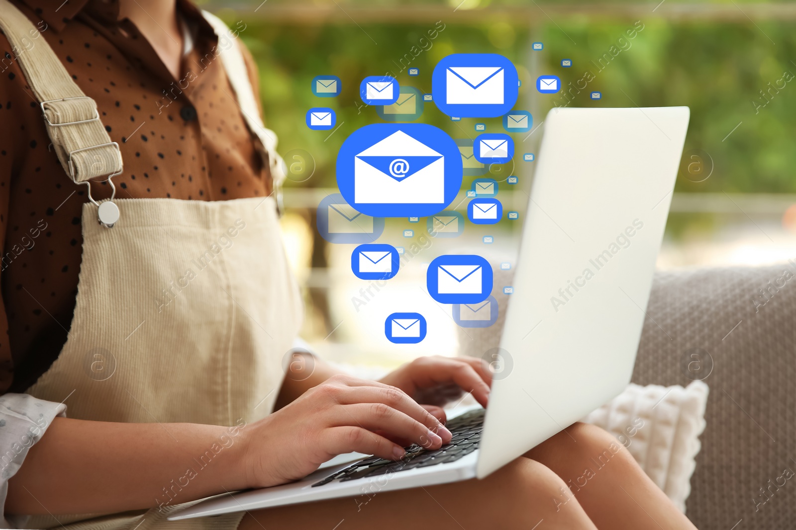 Image of Woman sending emails near window at home, closeup