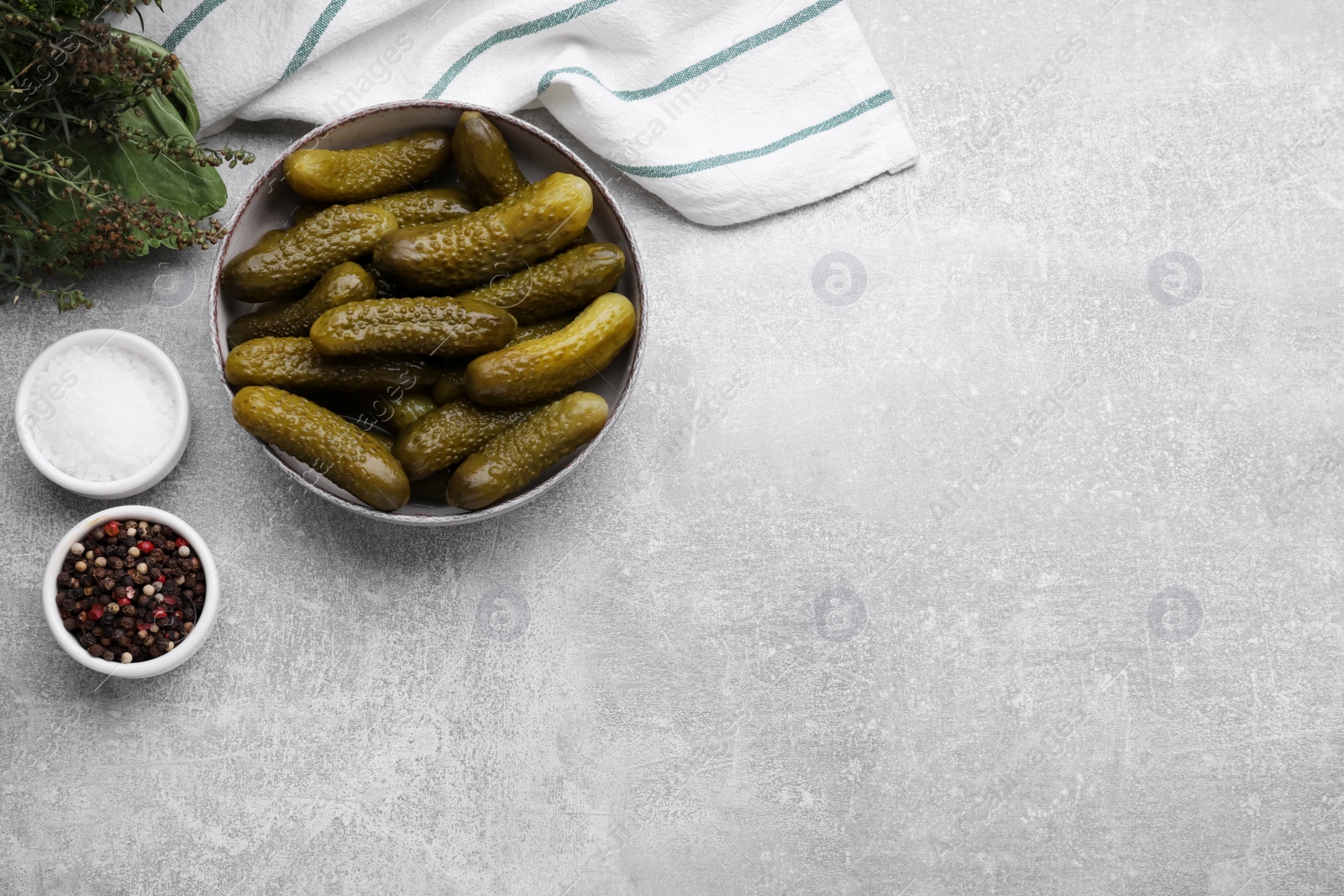 Photo of Pickled cucumbers and ingredients on light grey table, flat lay. Space for text