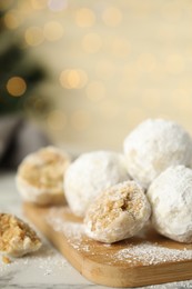 Photo of Tasty snowball cookies on wooden board, closeup. Christmas treat