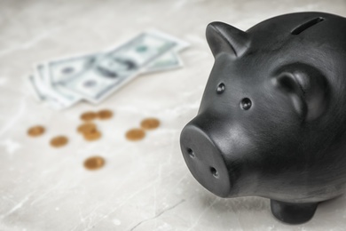 Photo of Black piggy bank and money on table