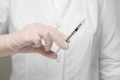 Doctor holding syringe with needle, closeup view