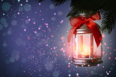 Image of Christmas lantern with candle hanging on fir tree branch, space for text. Magical atmosphere 