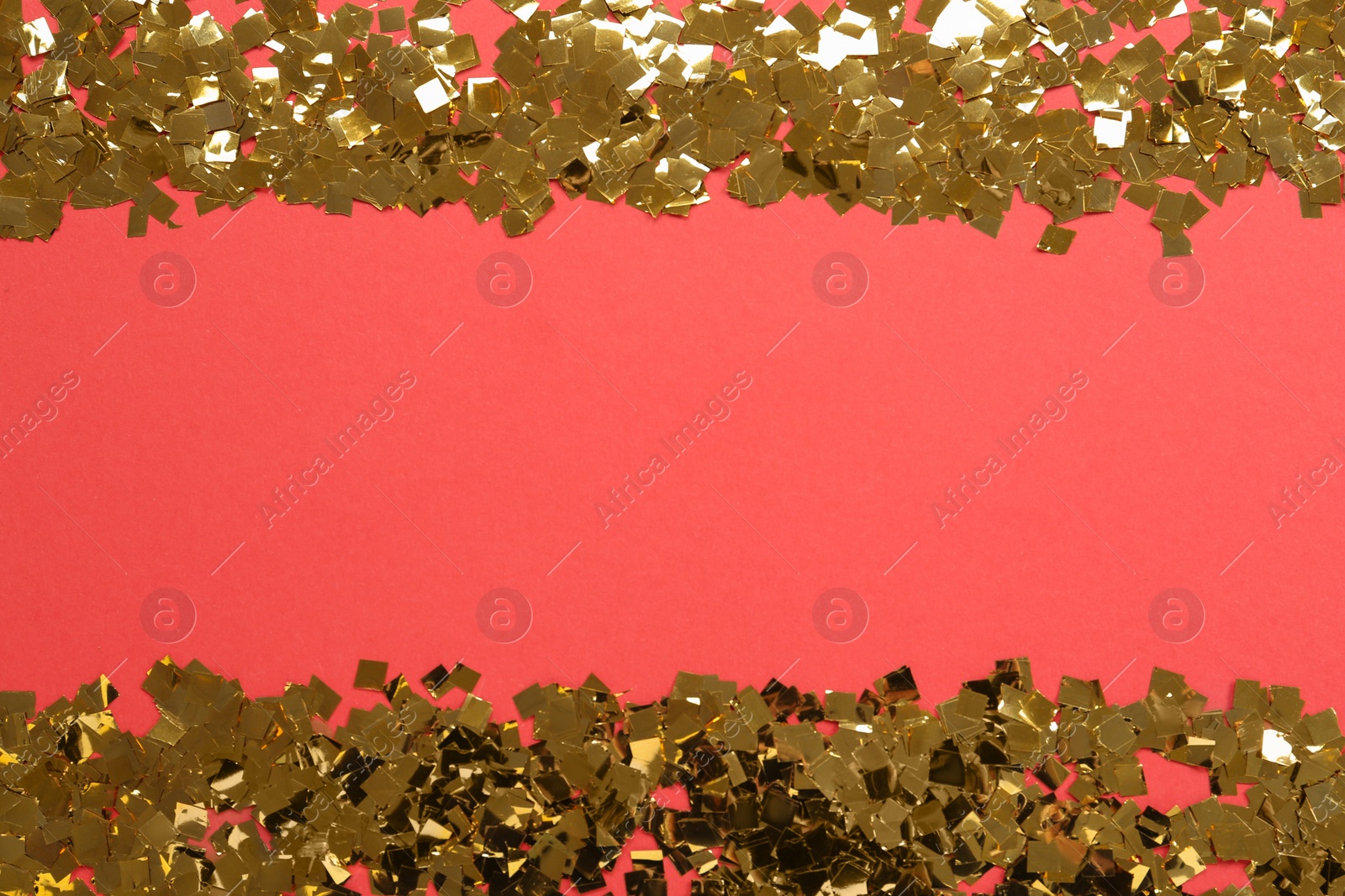 Photo of Shiny golden confetti on red background, flat lay. Space for text