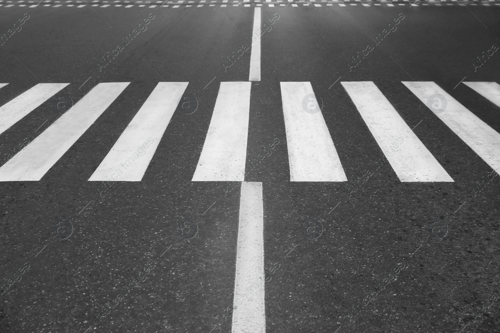 Photo of White pedestrian crossing on empty city street