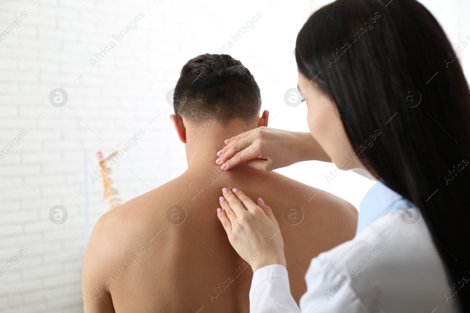 Photo of Professional orthopedist examining man in medical office