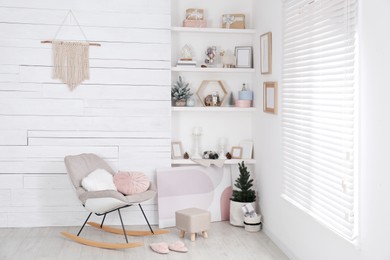 Photo of Stylish room interior with rocking chair, wall shelves and beautiful Christmas decor