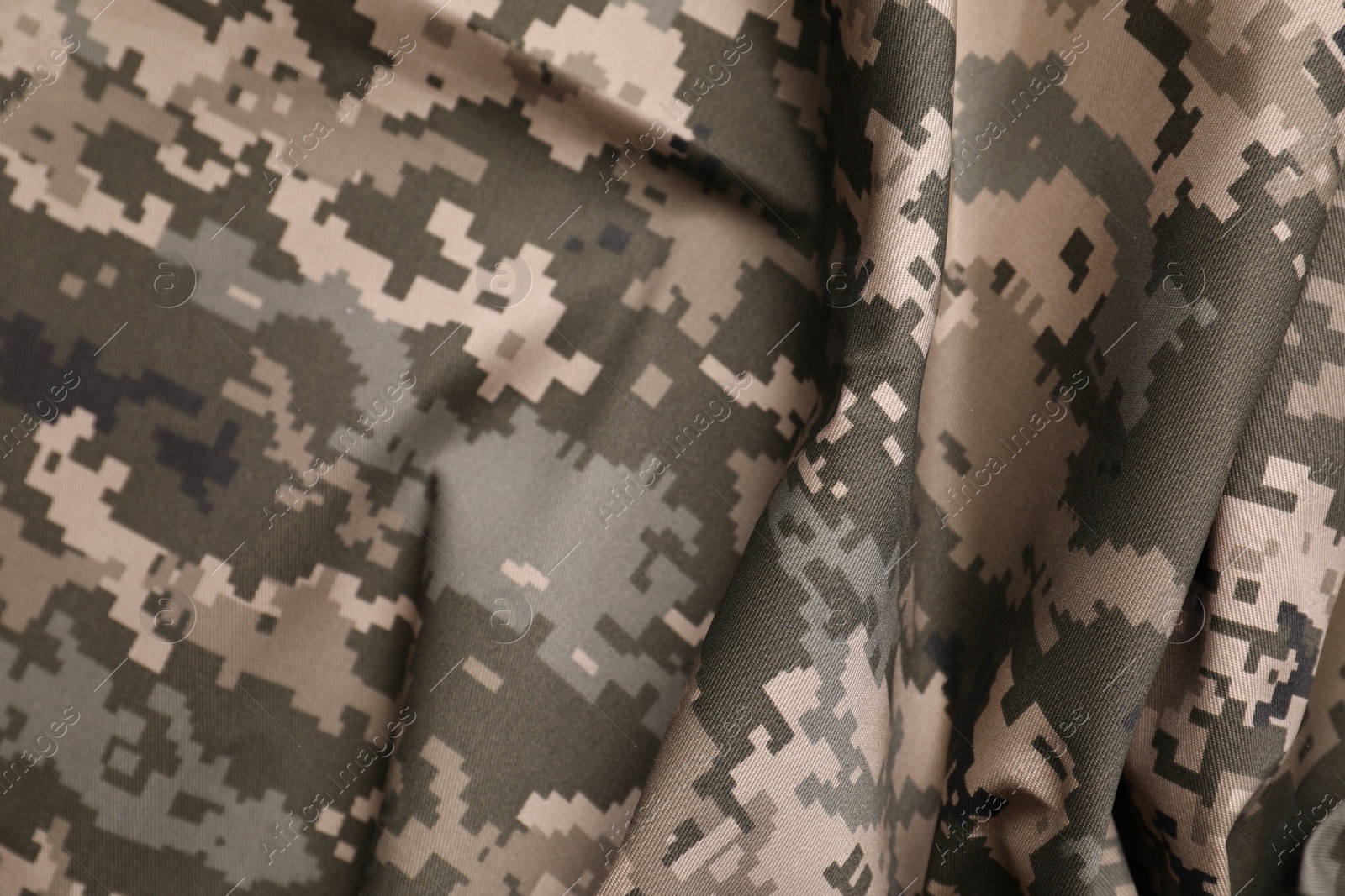 Photo of Texture of crumpled camouflage fabric as background, top view