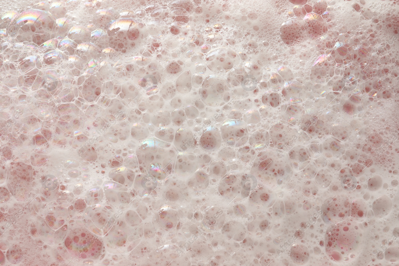 Photo of White washing foam on pale pink background, top view