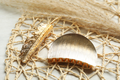 Photo of Beautiful gold hair clips on white table