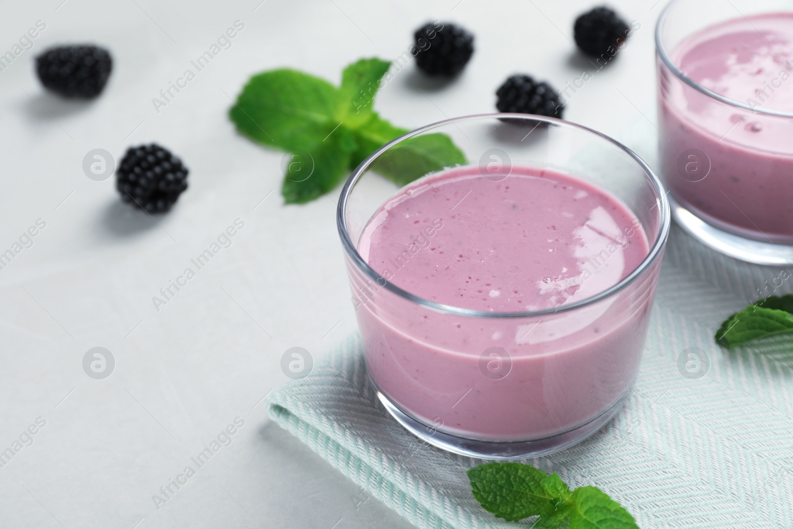 Photo of Glasses with tasty blackberry yogurt smoothies on table