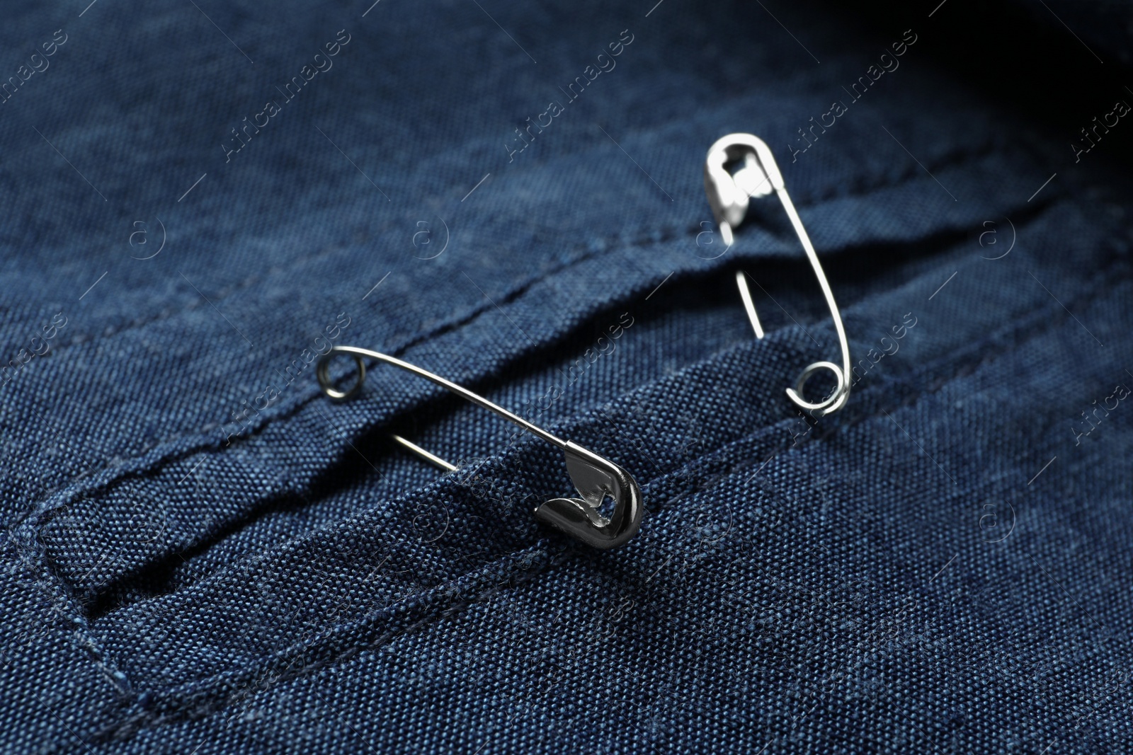 Photo of Closeup view of metal safety pins on clothing