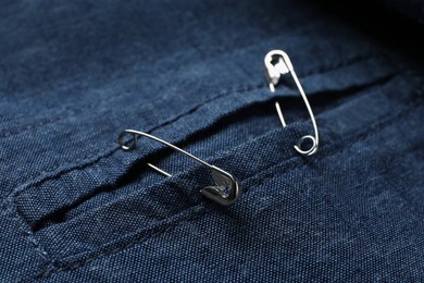 Closeup view of metal safety pins on clothing