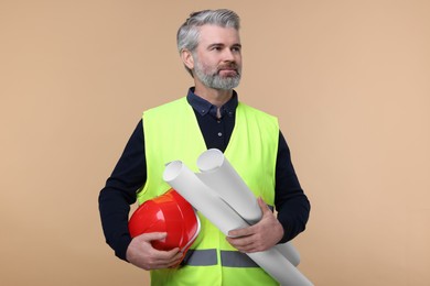 Photo of Architect with hard hat and drafts on beige background
