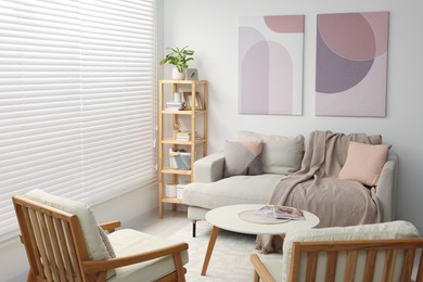 Photo of Stylish living room interior with sofa, coffee table and armchairs