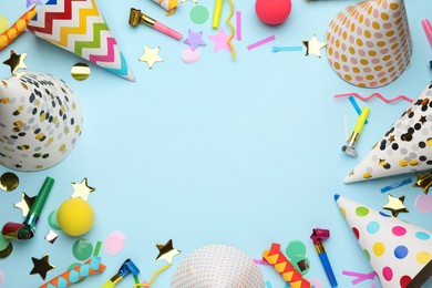 Photo of Flat lay composition with party hats and other festive items on light blue background. Space for text