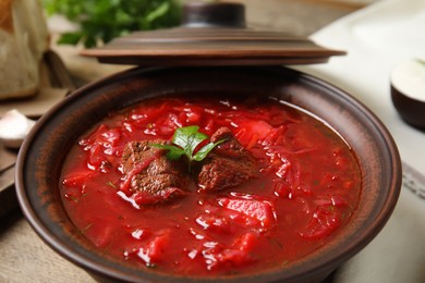 Photo of Stylish brown clay bowl with Ukrainian borsch, closeup