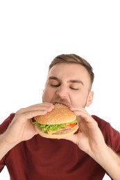 Photo of Young man eating tasty burger on white background