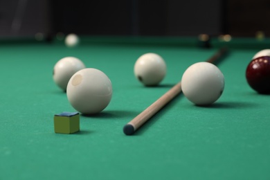 Photo of Billiard balls, cue and chalk on table